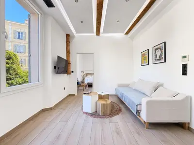 a white bedroom with a bed and a window at Nova - near sea and beaches in Cannes