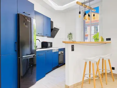 a kitchen with blue cabinets and a blue refrigerator at Nova - near sea and beaches in Cannes