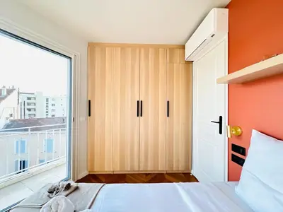 a bedroom with a bed and a large window at Le Clemenceau - Cannes Mer Belle Vue in Cannes