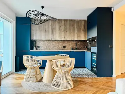 a kitchen with blue walls and a table and chairs at Le Clemenceau - Cannes Mer Belle Vue in Cannes