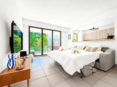 a white bedroom with a large bed and a couch at Terranova Cannes Terrace Accommodation in Cannes