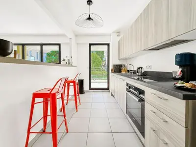 a kitchen with red stools in a white kitchen at Terranova Cannes Terrace Accommodation in Cannes