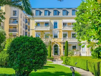 a large yellow building with trees in front of it at Terranova Cannes Terrace Accommodation in Cannes