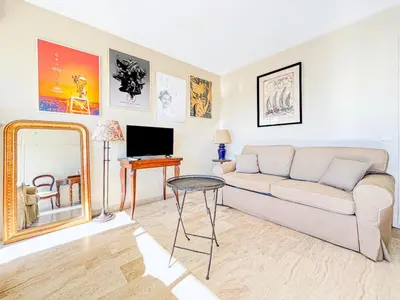 a living room with a couch and a mirror at Cannes Montfleury - Comfortable accommodation Center in Cannes