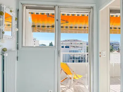 a room with a window with a chair on a balcony at Cannes Montfleury - Comfortable accommodation Center in Cannes