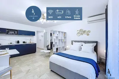 a bedroom with a bed and a desk and a kitchen at Le Gatsby - 2 pers - 10 min Palais - AC in Cannes