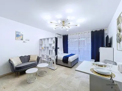 a living room with a bed and a couch and a table at Le Gatsby - 2 pers - 10 min Palais - AC in Cannes
