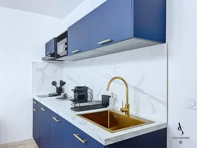 a kitchen with blue cabinets and a sink at Le Gatsby - 2 pers - 10 min Palais - AC in Cannes