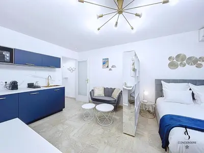 a bedroom with a bed and a kitchen and a room at Le Gatsby - 2 pers - 10 min Palais - AC in Cannes