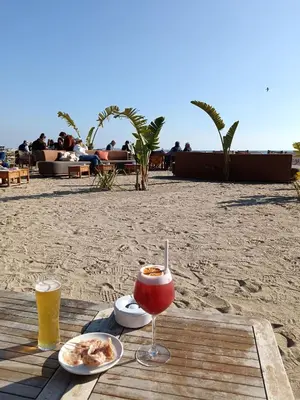 a table with a drink and food on the beach at Cannes superbe appt 3 pces Wi-Fi Clim Piscine Vue sur les îles et les Paquebots in Cannes