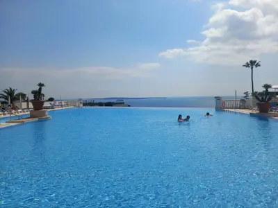 two people swimming in a large swimming pool at Cannes superbe appt 3 pces Wi-Fi Clim Piscine Vue sur les îles et les Paquebots in Cannes