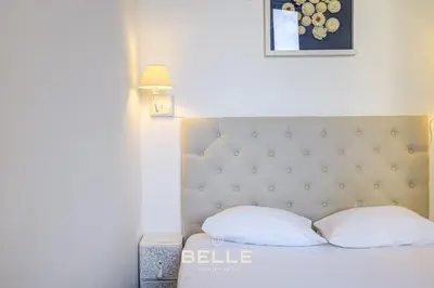 a bed with two pillows and a picture on the wall at Le Mimosa in Cannes