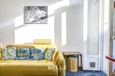 a living room with a yellow couch with pillows at Le Mimosa in Cannes