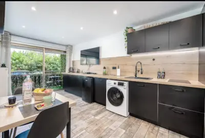 a kitchen with black cabinets and a dishwasher at Studio tout confort proche Mer et Croisette in Cannes