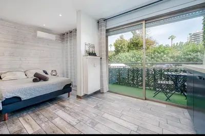 a bedroom with a bed and a large window at Studio tout confort proche Mer et Croisette in Cannes