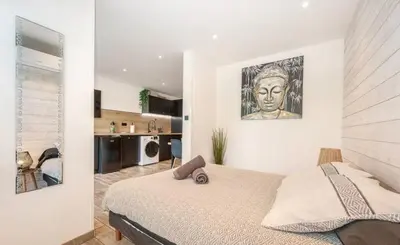 a bedroom with a bed with a painting on the wall at Studio tout confort proche Mer et Croisette in Cannes