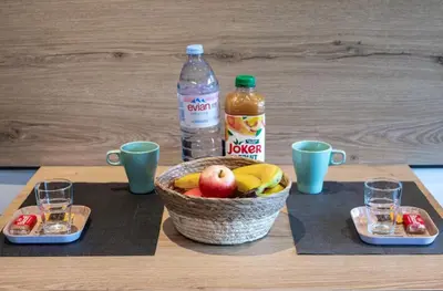 a table with a basket of fruit and two bottles of water at Studio tout confort proche Mer et Croisette in Cannes