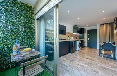 a living room with a bench and a kitchen at Studio tout confort proche Mer et Croisette in Cannes