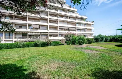 a large building with a grassy yard in front of it at Studio tout confort proche Mer et Croisette in Cannes