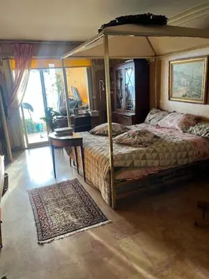 a bedroom with a canopy bed and a rug at Rocamare, la Vie est Belle! in Cannes