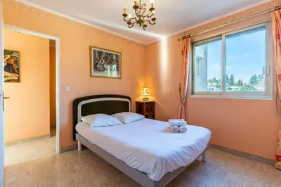 a bedroom with a bed and a window at La Terrasse du Riou – Soleil Plages à Cannes in Cannes