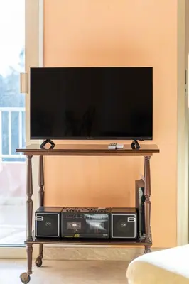 a flat screen tv on a table with consoles at La Terrasse du Riou – Soleil Plages à Cannes in Cannes