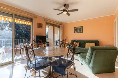 a living room with a table and chairs at La Terrasse du Riou – Soleil Plages à Cannes in Cannes