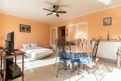 a living room with a table and a bed at La Terrasse du Riou – Soleil Plages à Cannes in Cannes