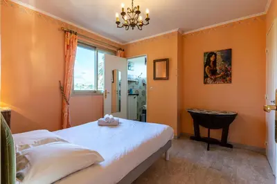 a bedroom with orange walls and a bed and a window at La Terrasse du Riou – Soleil Plages à Cannes in Cannes