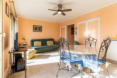 a living room with a table and chairs and a couch at La Terrasse du Riou – Soleil Plages à Cannes in Cannes