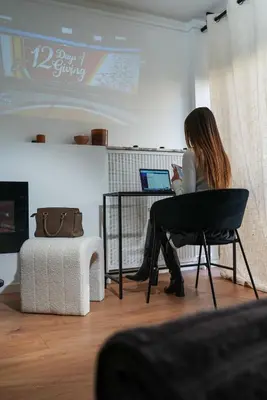 a woman sitting at a desk with a laptop at StudioLuxCannes - Suite premium avec baignoire à Cannes, plage à 2 min et Palais des Festivals in Cannes