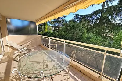 a balcony with a glass table and chairs at HENRI CAMILLE RE - Passy1 -Beautiful one bedroom swimming pool and parking in Cannes