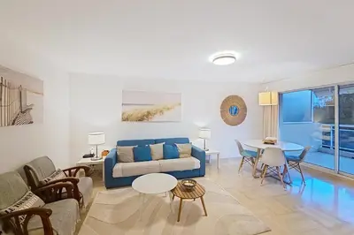 a living room with a blue couch and a table at HENRI CAMILLE RE - Passy1 -Beautiful one bedroom swimming pool and parking in Cannes
