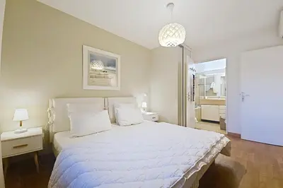 a bedroom with a large white bed with white pillows at HENRI CAMILLE RE - Passy1 -Beautiful one bedroom swimming pool and parking in Cannes