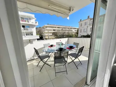a balcony with a glass table and chairs on a patio at Cannes Maria in Cannes