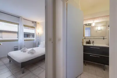 a bedroom with a bed and a bathroom with a sink at 1-Br Apartment Palm Beach Near Beaches & La Croisette in Cannes