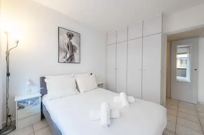 a white bedroom with a large white bed with white pillows at 1-Br Apartment Palm Beach Near Beaches & La Croisette in Cannes