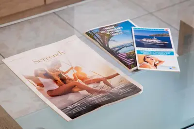 two magazines sitting on top of a glass table at 1-Br Apartment Palm Beach Near Beaches & La Croisette in Cannes