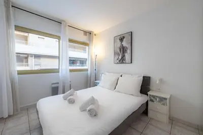 a bedroom with a white bed with towels on it at 1-Br Apartment Palm Beach Near Beaches & La Croisette in Cannes