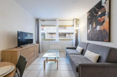 a living room with a couch and a tv at 1-Br Apartment Palm Beach Near Beaches & La Croisette in Cannes