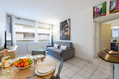 a living room with a table and a couch at 1-Br Apartment Palm Beach Near Beaches & La Croisette in Cannes