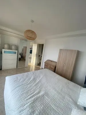 a bedroom with a large white bed and a mirror at Primavera in Cannes