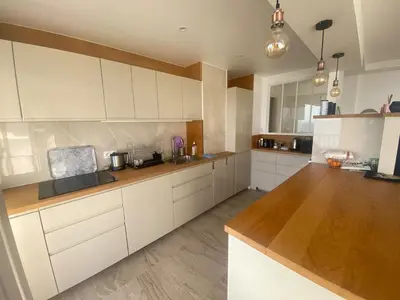 a kitchen with white cabinets and a wooden counter top at Primavera in Cannes
