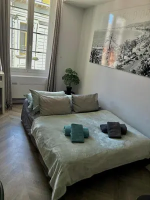 a large bed in a room with two pillows on it at Heart of Cannes Azure Home in Cannes