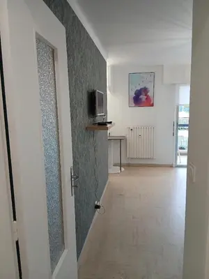 a living room with a couch and a kitchen at Studio LE MEDITERRANEE in Cannes