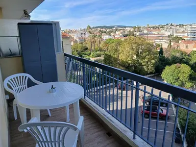 a white table and chairs on a balcony with a view at Studio LE MEDITERRANEE in Cannes
