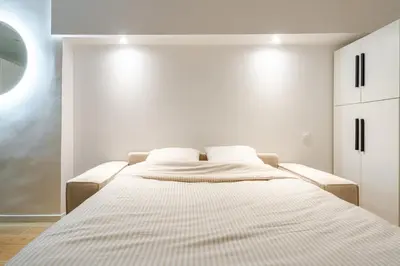 a white bedroom with a bed with a striped mattress at Élégant 2P Rue Meynadier Proche du Palais et des plages in Cannes