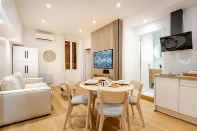 a kitchen and living room with a table and chairs at Élégant 2P Rue Meynadier Proche du Palais et des plages in Cannes