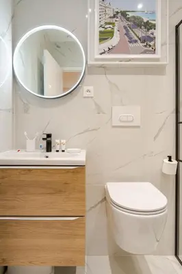 a bathroom with a white toilet and a mirror at Élégant 2P Rue Meynadier Proche du Palais et des plages in Cannes