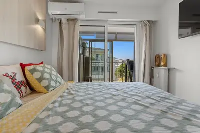 a bedroom with a large bed and a balcony at 11 MADRID - Splendid one-bedroom apartment near Croisette in Cannes
